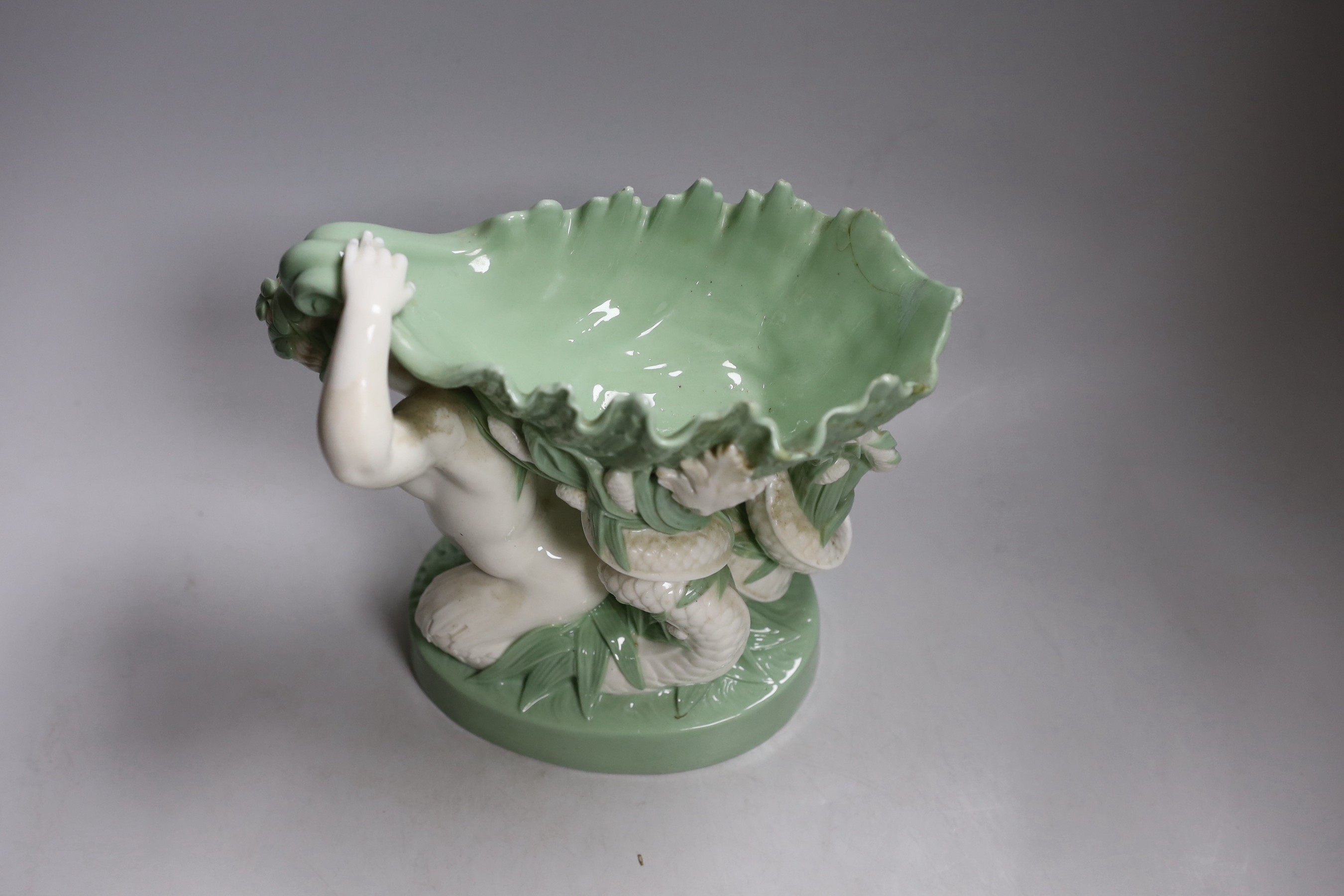 A 19th century Minton celadon glazed figure of a mermaid with a shell on her back, 21cm tall